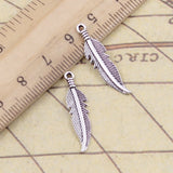 30 piezas de dijes de hojas y plumas de 27 x 7 mm, colgantes de bronce tibetano color plata, joyería antigua, accesorios artesanales hechos a mano. 